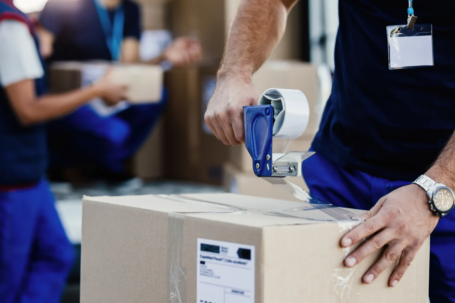 unit, storage units in Ohio, closeupdeliverymanclosingcarboardboxwithtapewhilepreparingpackagesshipment, self-storage, reserv